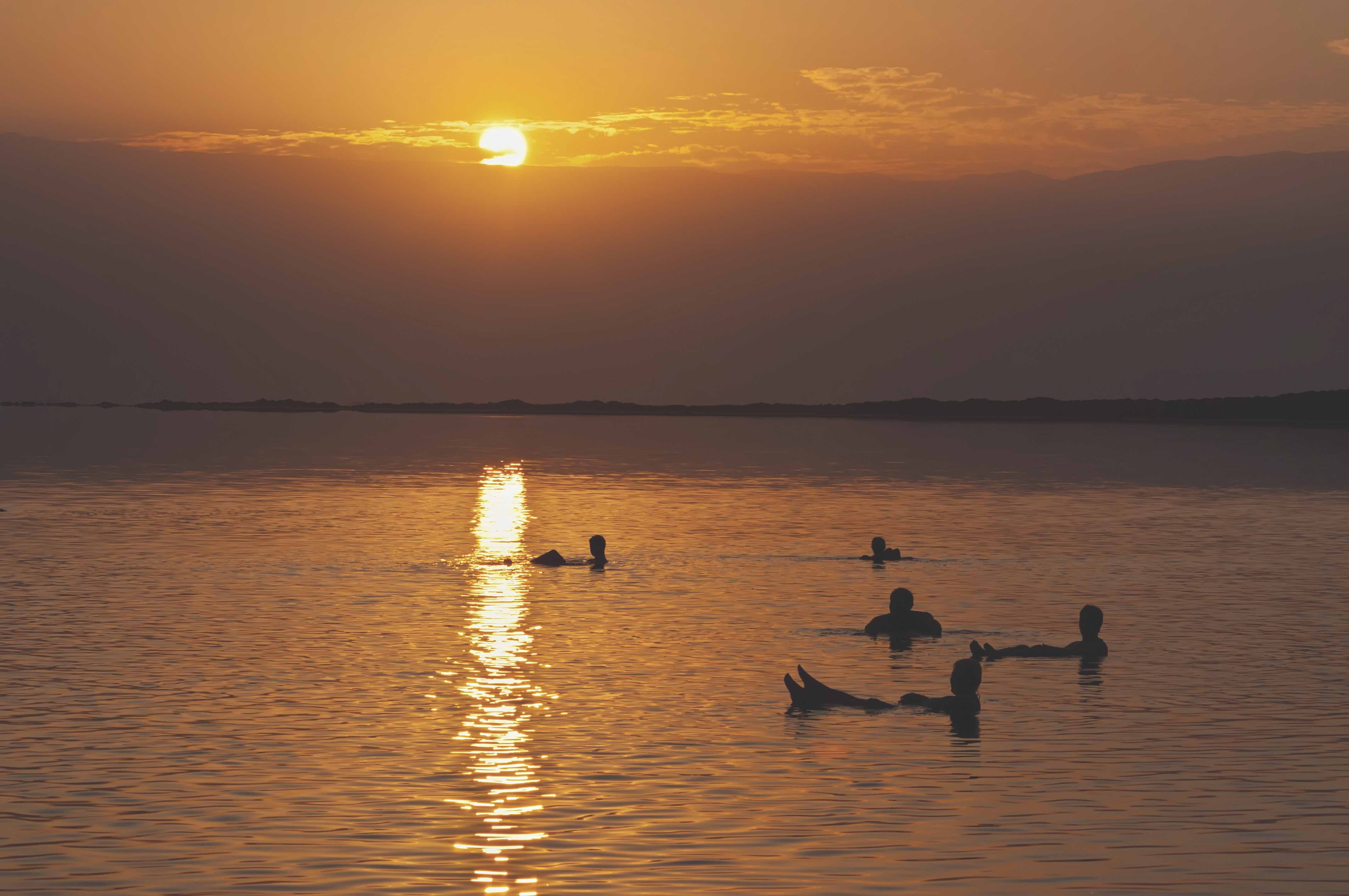 Small group watching the sunset and floating in the Dead Sea.