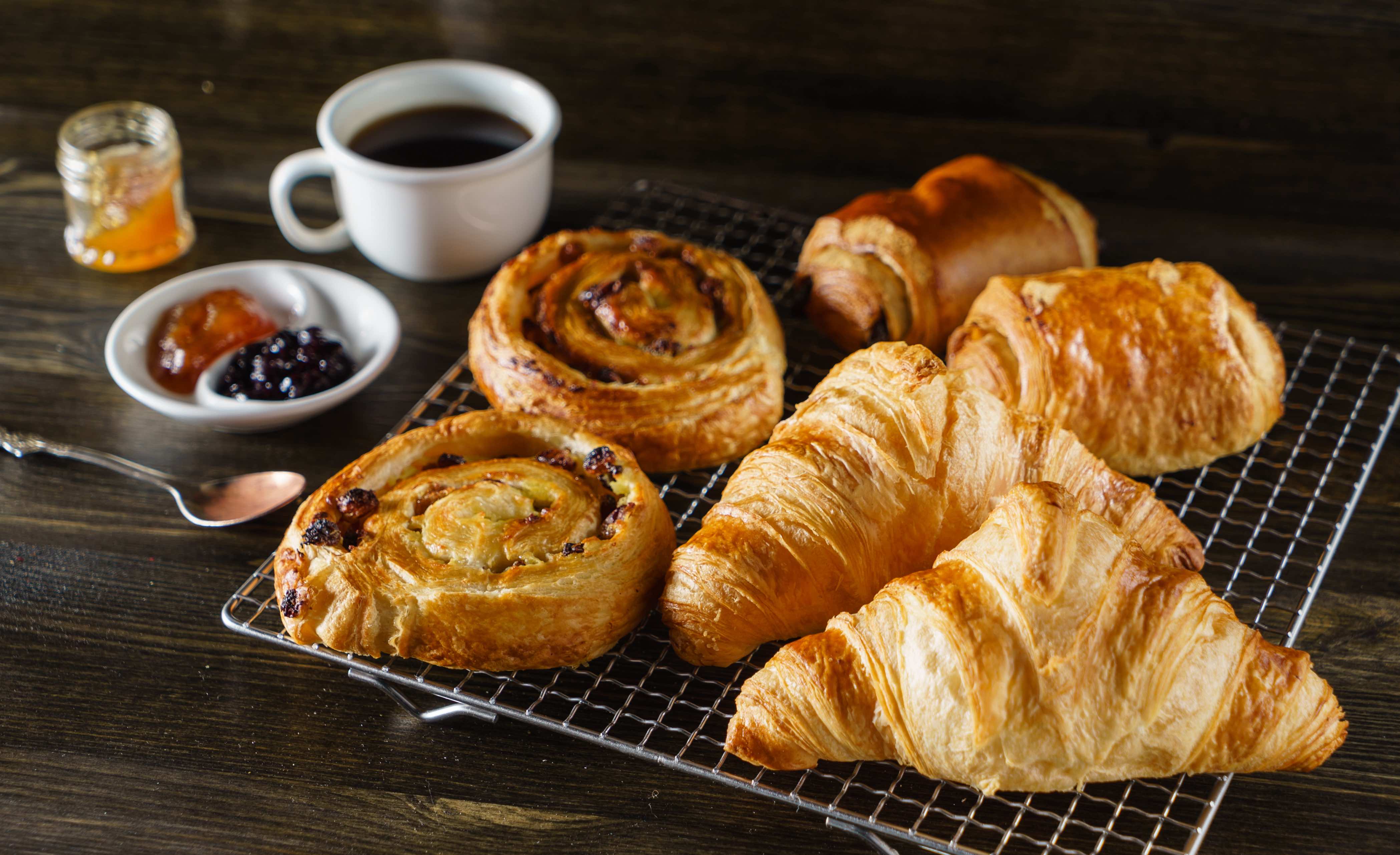 Coffee, French pastries and jam on a table