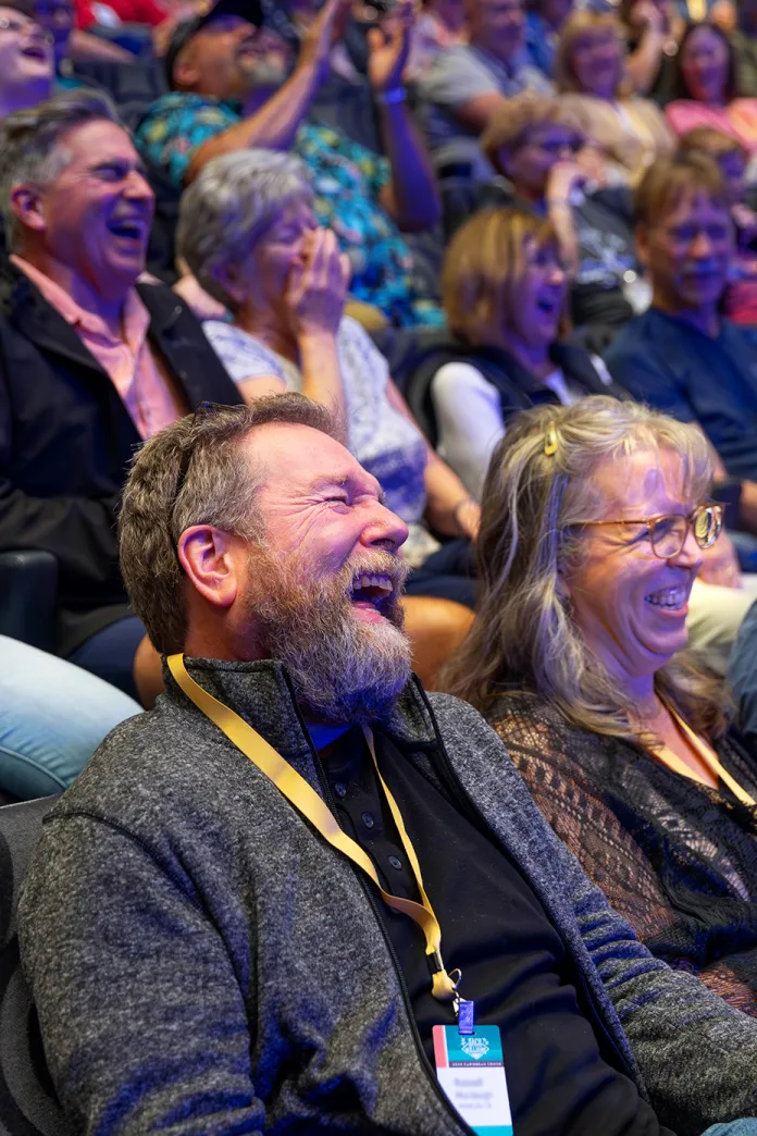 People in an auditorium laughing