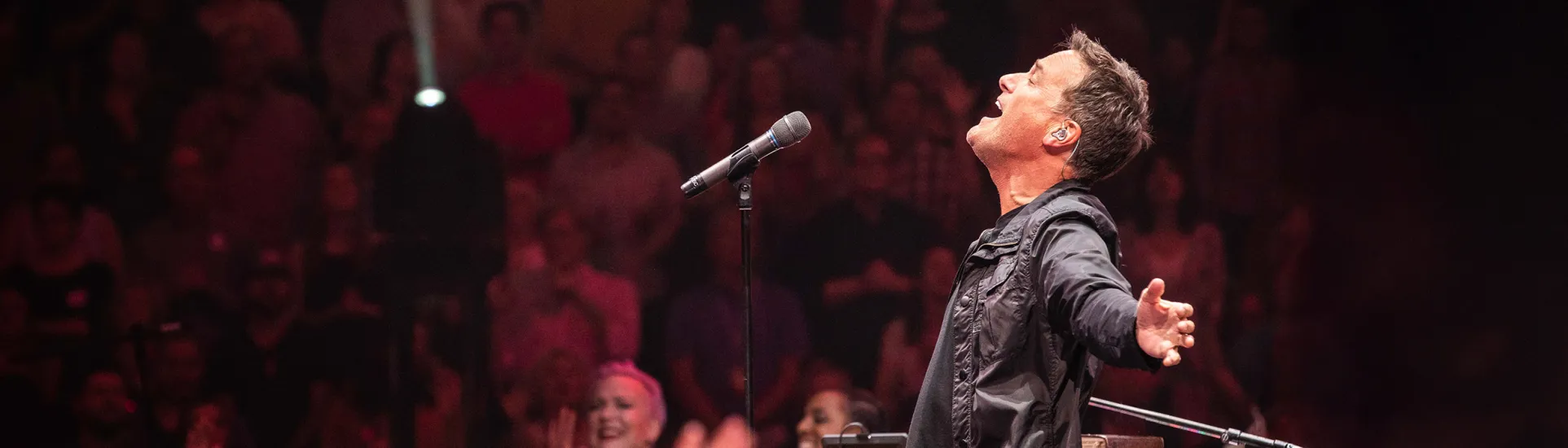 Michael W. Smith singing with arms spread open and head back