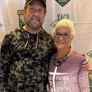 Zach Williams smiling for a photo with a traveler