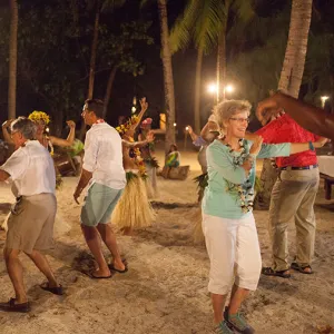 A group of travelers dancing on the sandy beach